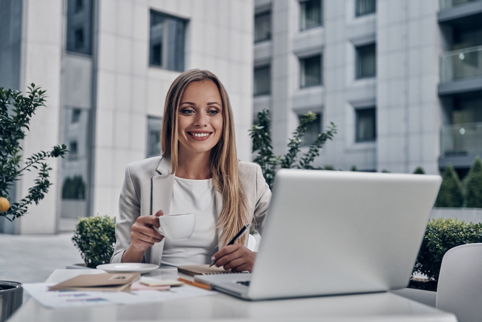 Woman sitting at desk writing on note pad